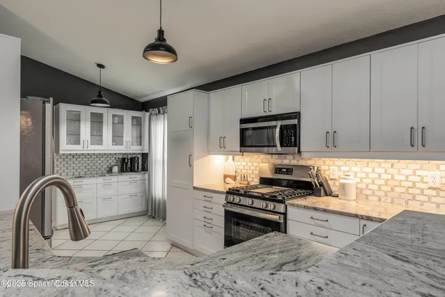 a kitchen with stainless steel appliances granite countertop a stove and a sink