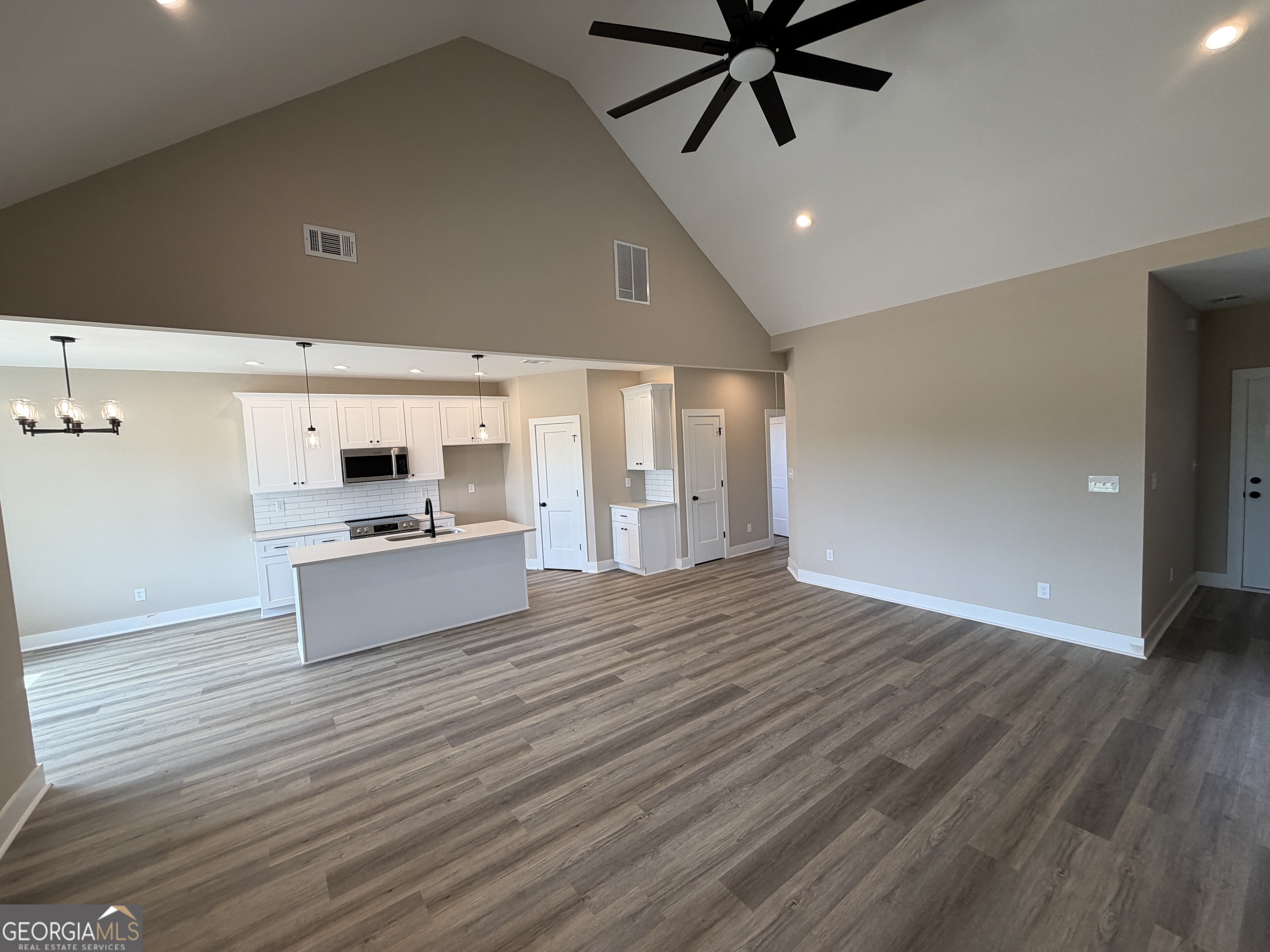 54 Melville Brown Road Williamson, GA 30292 - Photo 4 of 16 a kitchen with stainless steel appliances kitchen island wooden floors and view living room