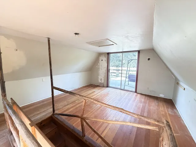 a room with a wooden floor and white walls