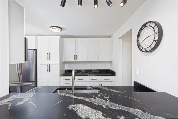 a kitchen with stainless steel appliances granite countertop a refrigerator and a stove