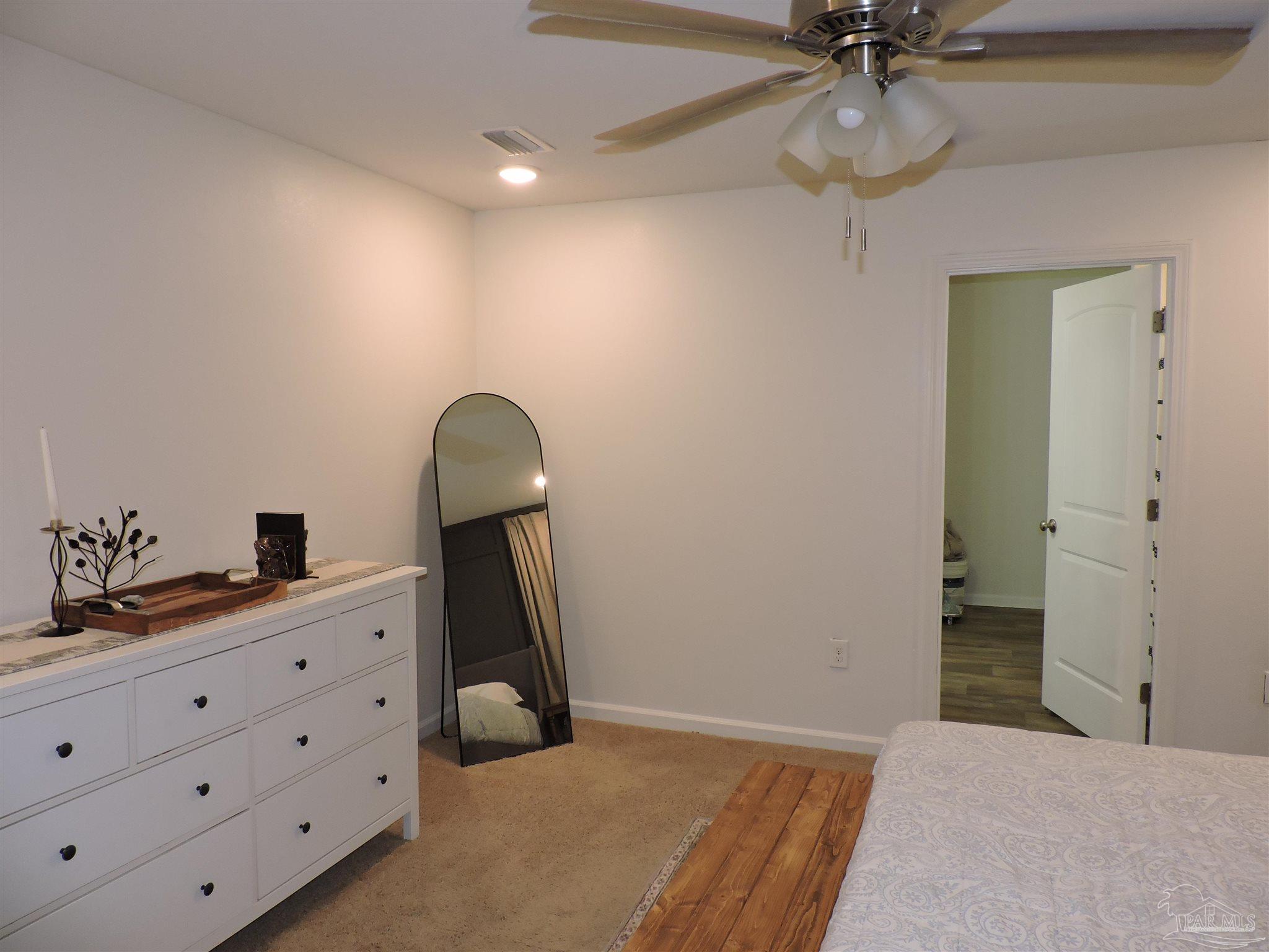 5840 Paddock Way Pensacola, FL 32526 - Photo 14 of 21 a bedroom with a chandelier fan and a dresser