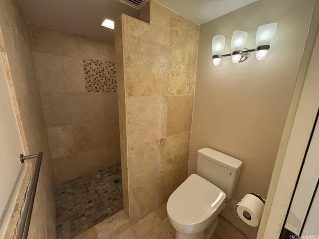 a white toilet sitting next to a bathroom sink and vanity