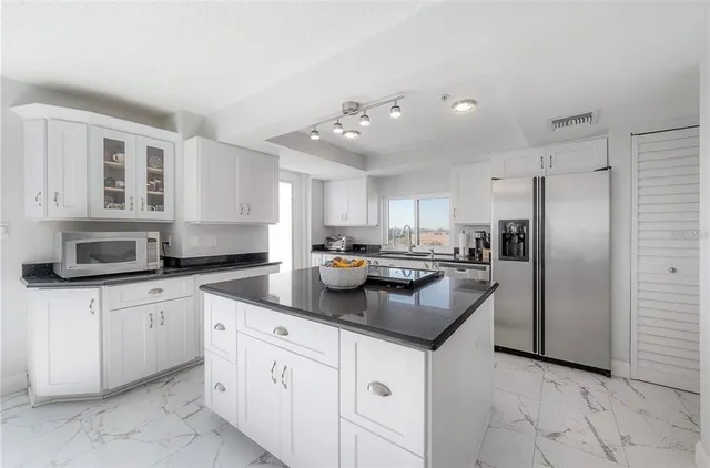 a kitchen with stainless steel appliances granite countertop a sink a stove and a refrigerator