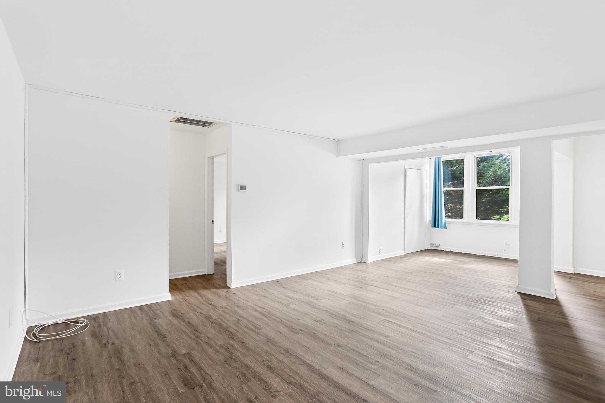 9629 White Acre Road, Unit B2 Columbia, MD 21045 - Photo 3 of 11 a view of an empty room with wooden floor and a window