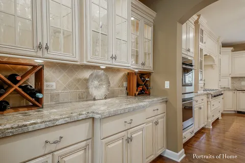 a kitchen with stainless steel appliances granite countertop a sink and dishwasher with white cabinets