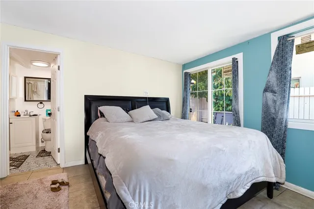 a large bed sitting in a bedroom next to a window