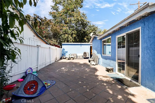 a view of a backyard with table and chairs and potted plants