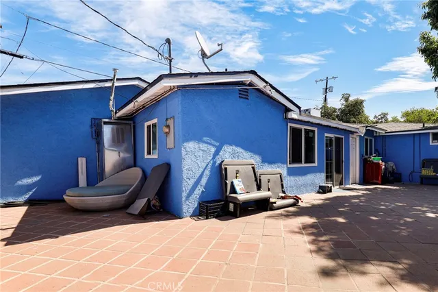 a view of a house with a barbeque and wooden stairs