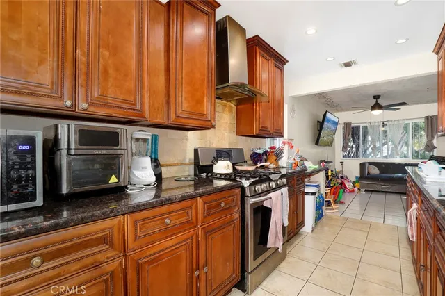 a kitchen with stainless steel appliances granite countertop a stove a sink and a microwave