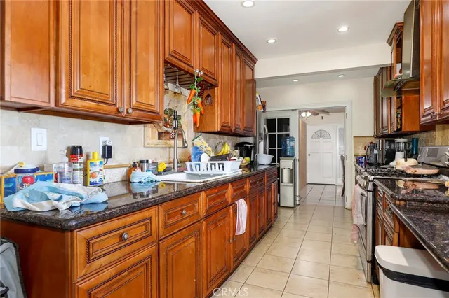 a kitchen with stainless steel appliances granite countertop a sink stove and refrigerator