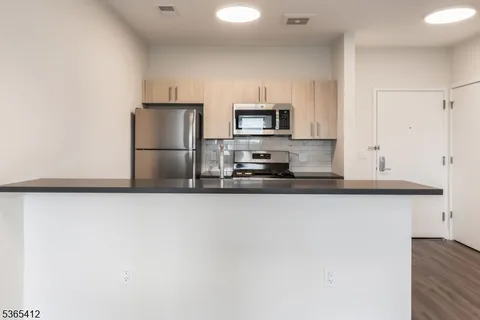 a kitchen with granite countertop a refrigerator a stove a microwave and cabinets