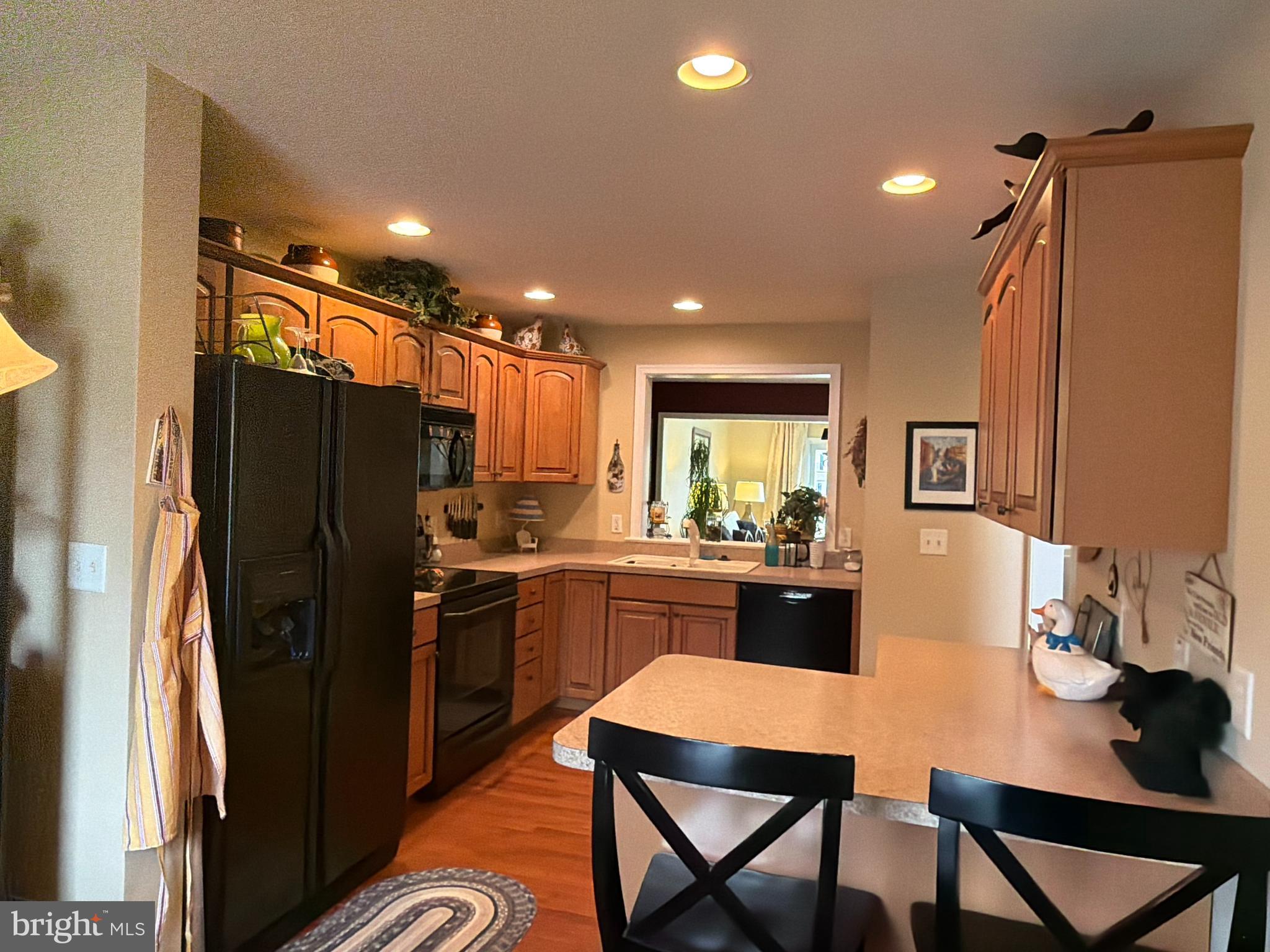 4245 Roth Farm Village Circle Mechanicsburg, PA 17050 - Photo 6 of 42 a kitchen with stainless steel appliances granite countertop a refrigerator a sink a stove a dining table and chairs with wooden floor