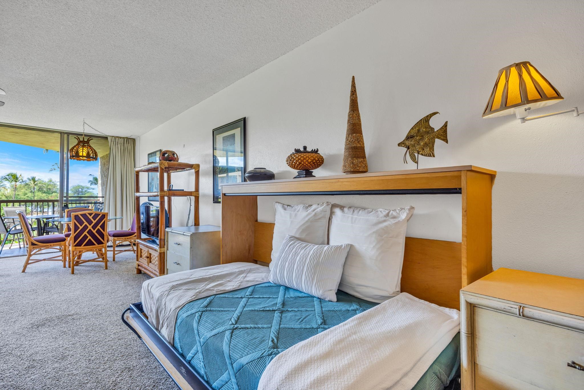 1032 South Kihei Road, Unit A412 Kihei, HI 96753 - Photo 26 of 43 a bedroom with a bed a table and chair