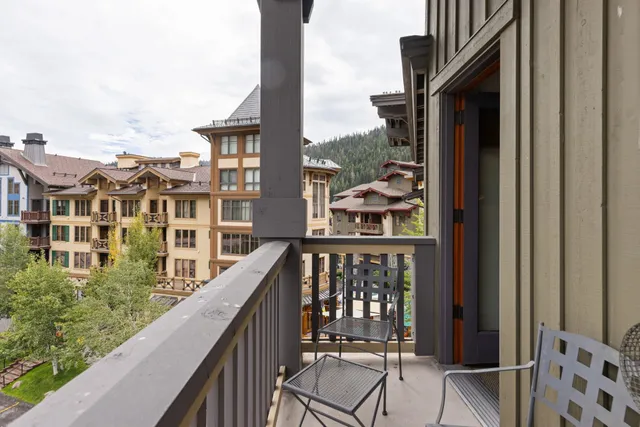 a view of a balcony with wooden floor and fence