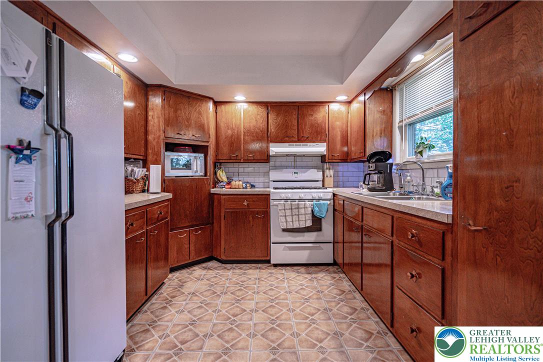 7562 Quarry Road Macungie, PA 18062 - Photo 14 of 35 a kitchen with stainless steel appliances granite countertop a refrigerator a sink dishwasher a stove with wooden cabinets and floor
