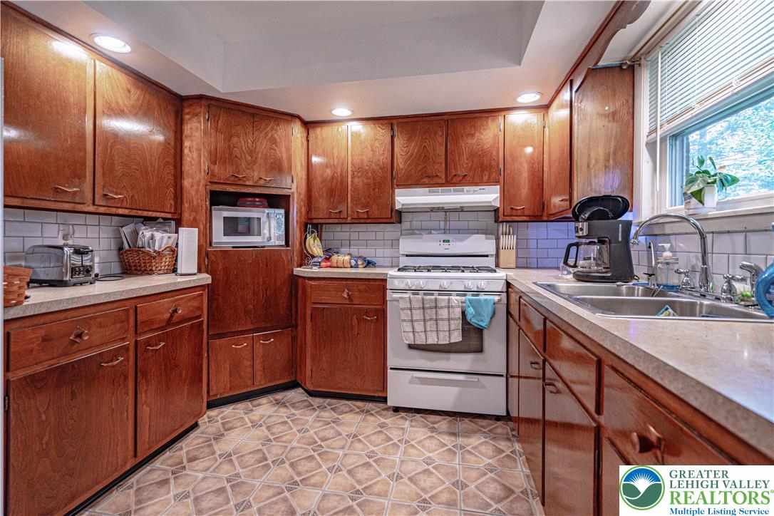 7562 Quarry Road Macungie, PA 18062 - Photo 15 of 35 a kitchen with stainless steel appliances granite countertop a sink stove and cabinets