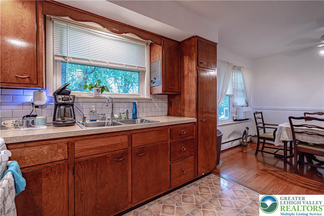 7562 Quarry Road Macungie, PA 18062 - Photo 17 of 35 a kitchen with stainless steel appliances granite countertop wooden cabinets a refrigerator a sink and a large window