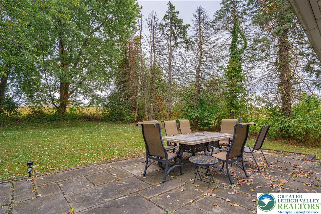 7562 Quarry Road Macungie, PA 18062 - Photo 26 of 35 a view of a wooden deck with table and chairs and potted plants