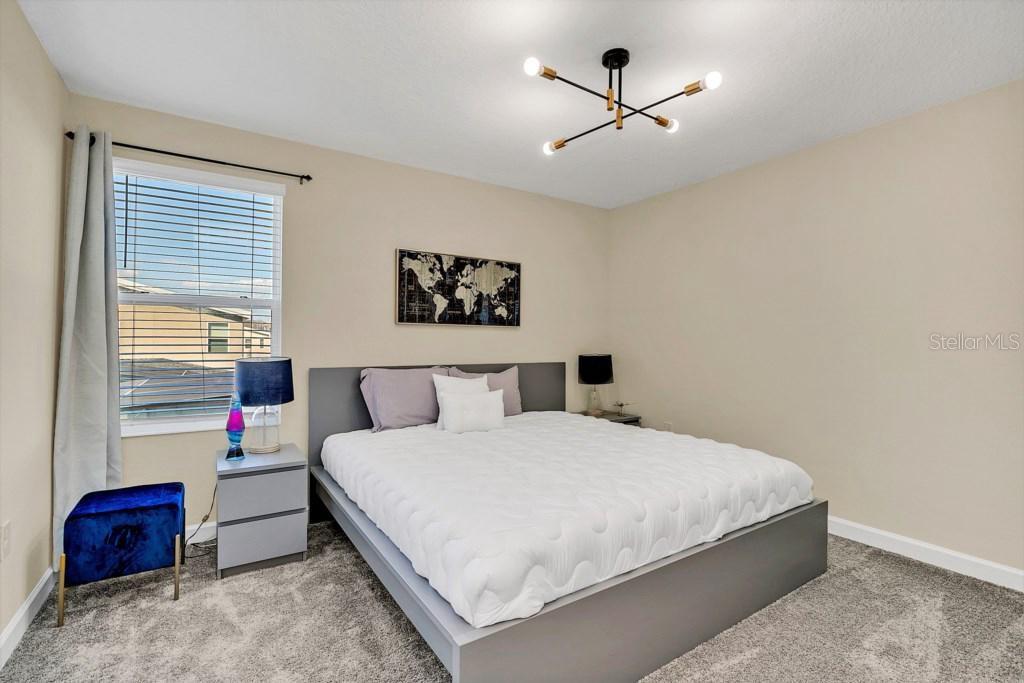 4541 Target Boulevard Kissimmee, FL 34746 - Photo 25 of 33 a bedroom with a large bed and a ceiling fan