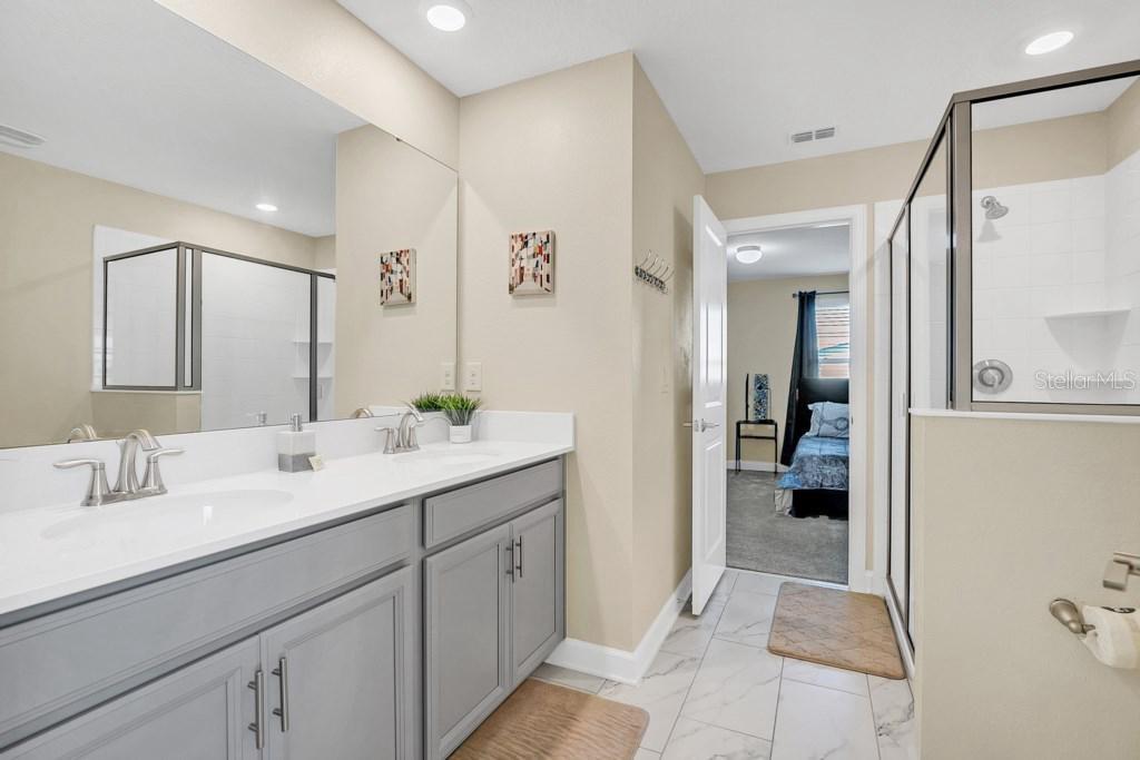 4541 Target Boulevard Kissimmee, FL 34746 - Photo 26 of 33 a en suite bathroom with a double vanity sink a mirror and shower