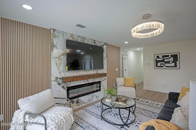 a living room with furniture and a chandelier
