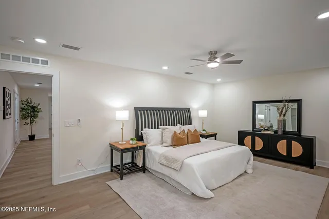 a spacious bedroom with a bed and a chandelier