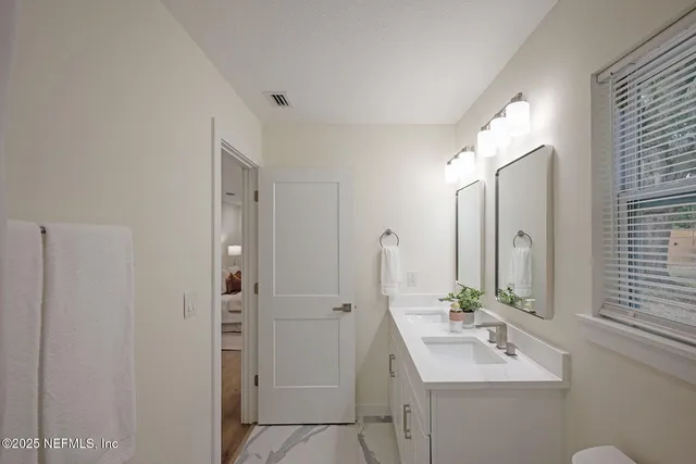 a bathroom with 2 sink and a mirror