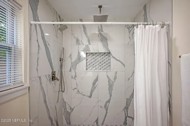 a bathroom with a shower sink vanity mirror and toilet