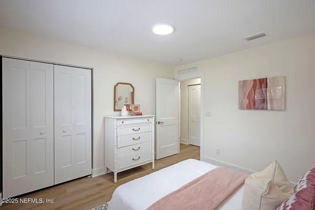 a spacious bedroom with a bed and a dresser