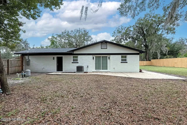 a large house with a big yard and large trees