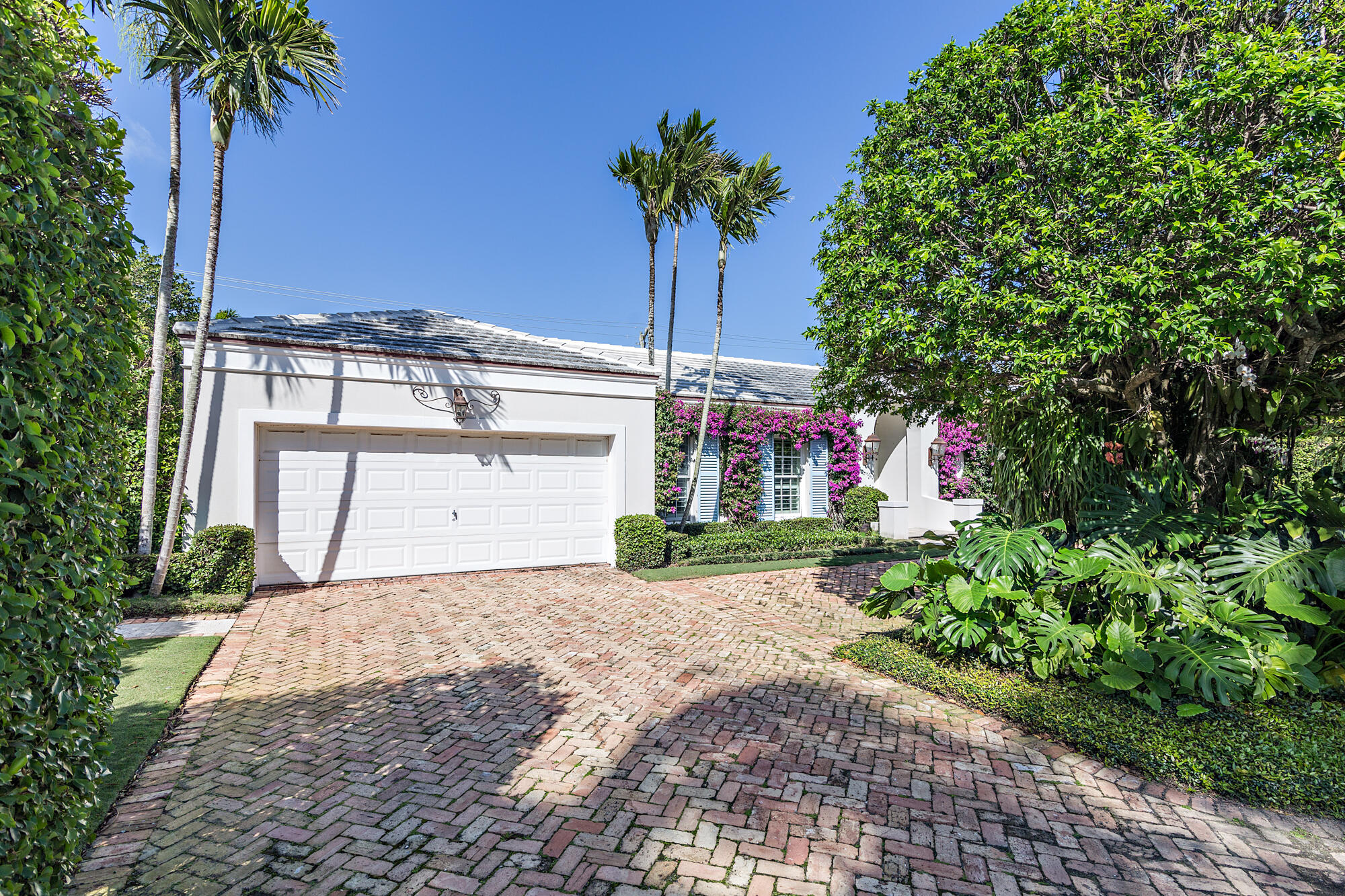 273 List Road Palm Beach, FL 33480 - Photo 21 of 26 a front view of a house with a yard and garage