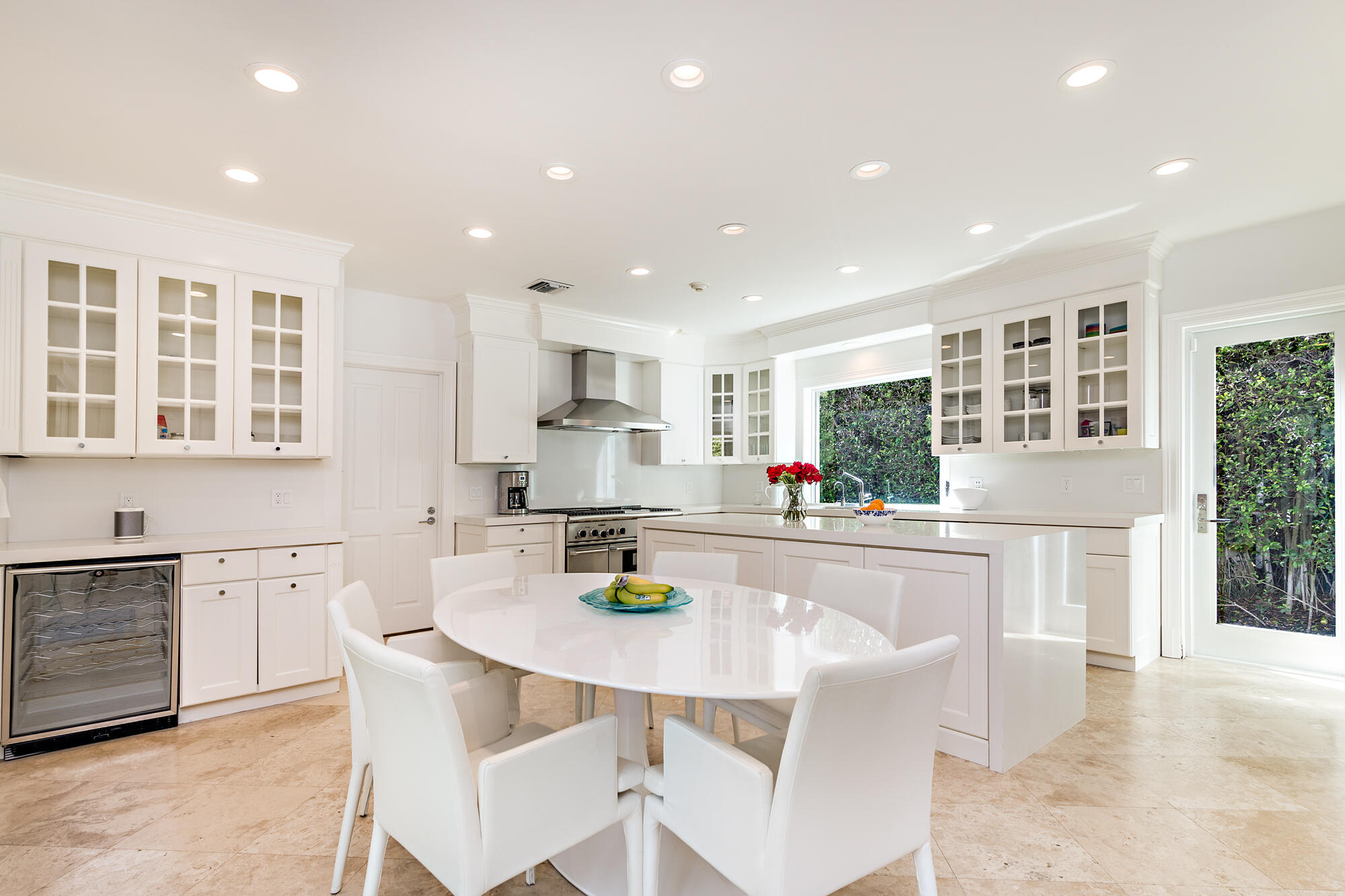 273 List Road Palm Beach, FL 33480 - Photo 7 of 26 a kitchen with stainless steel appliances granite countertop a refrigerator a stove top oven and a dining table with wooden floor