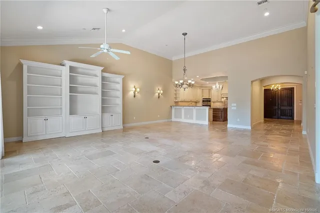 an empty room with chandelier and stainless steel appliances