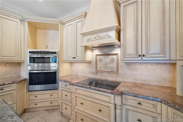 a kitchen with granite countertop white cabinets and stainless steel appliances