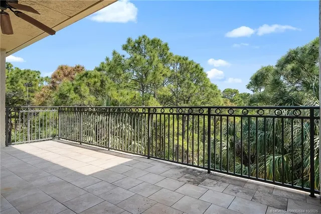 a view of a big room with windows and chandelier fan