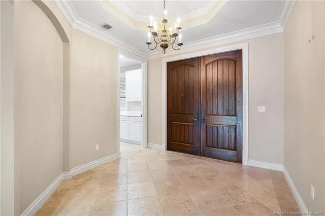 a view of a hallway with a chandelier fan