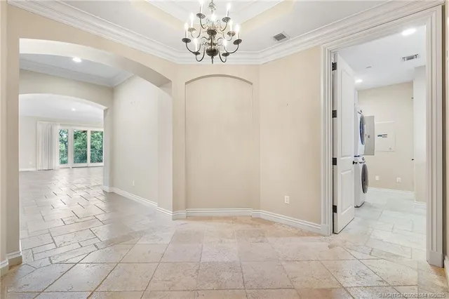 a view of a livingroom with a chandelier fan and windows