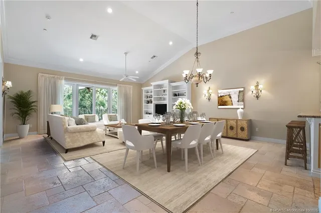 a dining room with furniture a chandelier and window