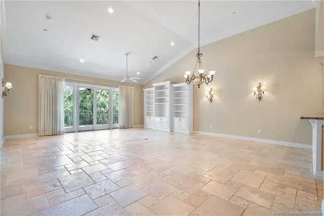 a view of a livingroom with a chandelier fan and windows
