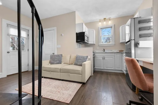 a living room with furniture a flat screen tv and wooden floor