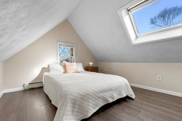 a bedroom with a bed and painting on the wall