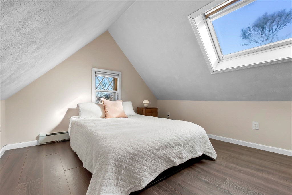 28 Columbus Avenue, Unit 4 Beverly, MA 01915 - Photo 16 of 25 a bedroom with a bed and painting on the wall