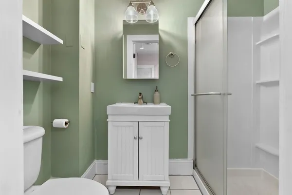 a bathroom with a sink a toilet and shower