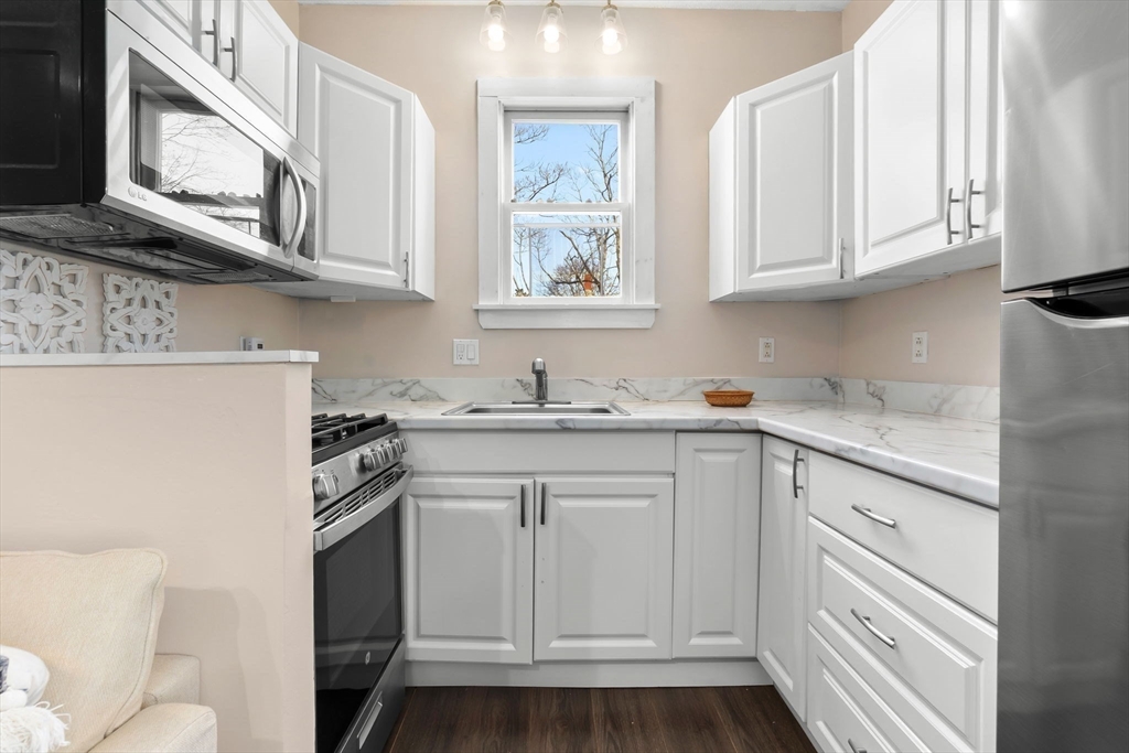 28 Columbus Avenue, Unit 4 Beverly, MA 01915 - Photo 8 of 25 a kitchen with stainless steel appliances granite countertop white cabinets and sink