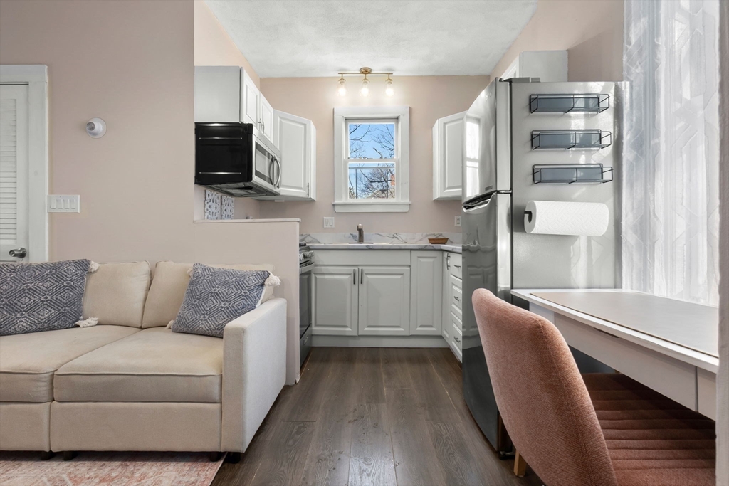 28 Columbus Avenue, Unit 4 Beverly, MA 01915 - Photo 9 of 25 a living room with furniture a flat screen tv and kitchen view