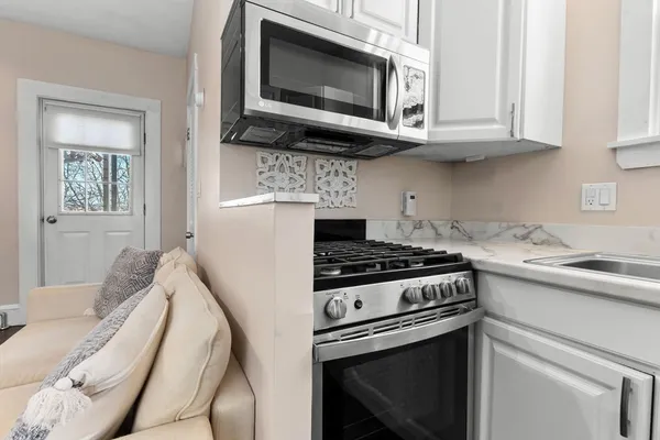 a kitchen with stainless steel appliances granite countertop a stove microwave and sink