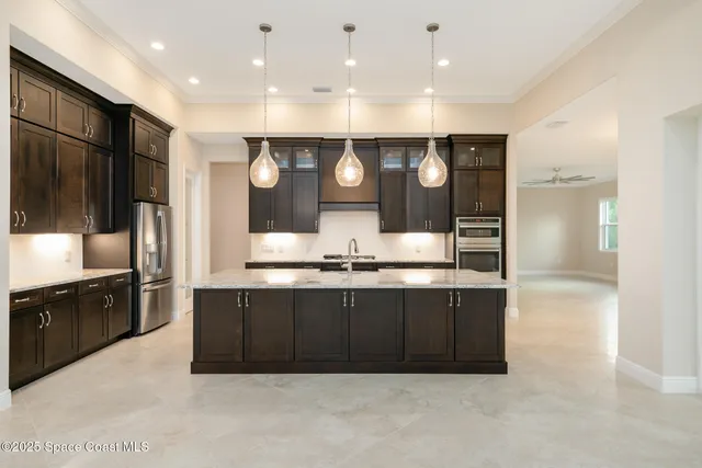 a kitchen with stainless steel appliances granite countertop a sink counter space cabinets and a wooden floor