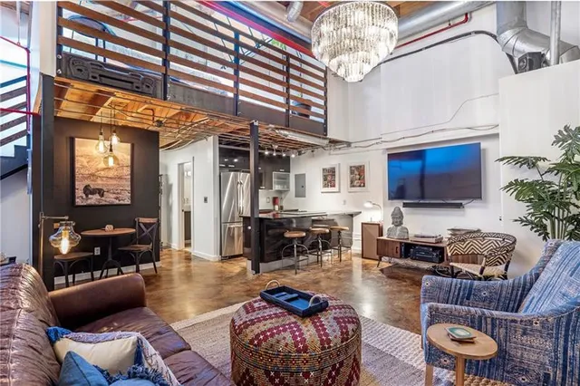 a living room with furniture a chandelier and a flat screen tv