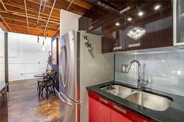 a kitchen with a sink a refrigerator and wooden floor