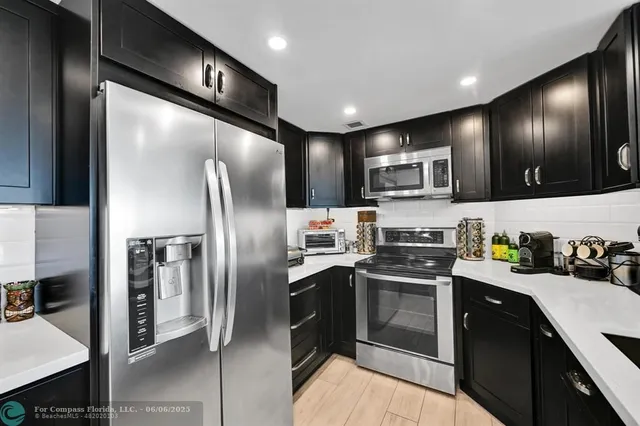 a kitchen with granite countertop stainless steel appliances cabinets a sink and a counter top space